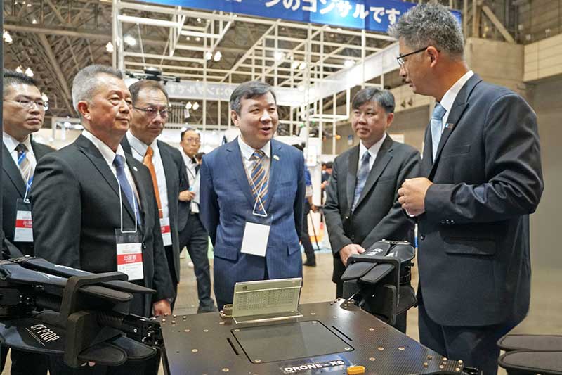 Japan Drone臺灣館開展首日，台北駐日經濟文化代表處李逸洋大使（左四）參觀工研院「物流無人機」。此技術專為偏遠地區配送需求打造，整合高效率馬達與模組化酬載設計，飛行穩定性且續航力強，可靈活因應各類物資運輸，已與日本無人機公司Tompla於神戶工業區完成餐點物流示範。
